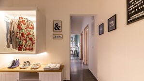 A hallway with a bench displaying shoes and a hanging garment. - Cosy apt near Piraeus central port, Mikrolimano port & Pasalimani port. (Pireas)
