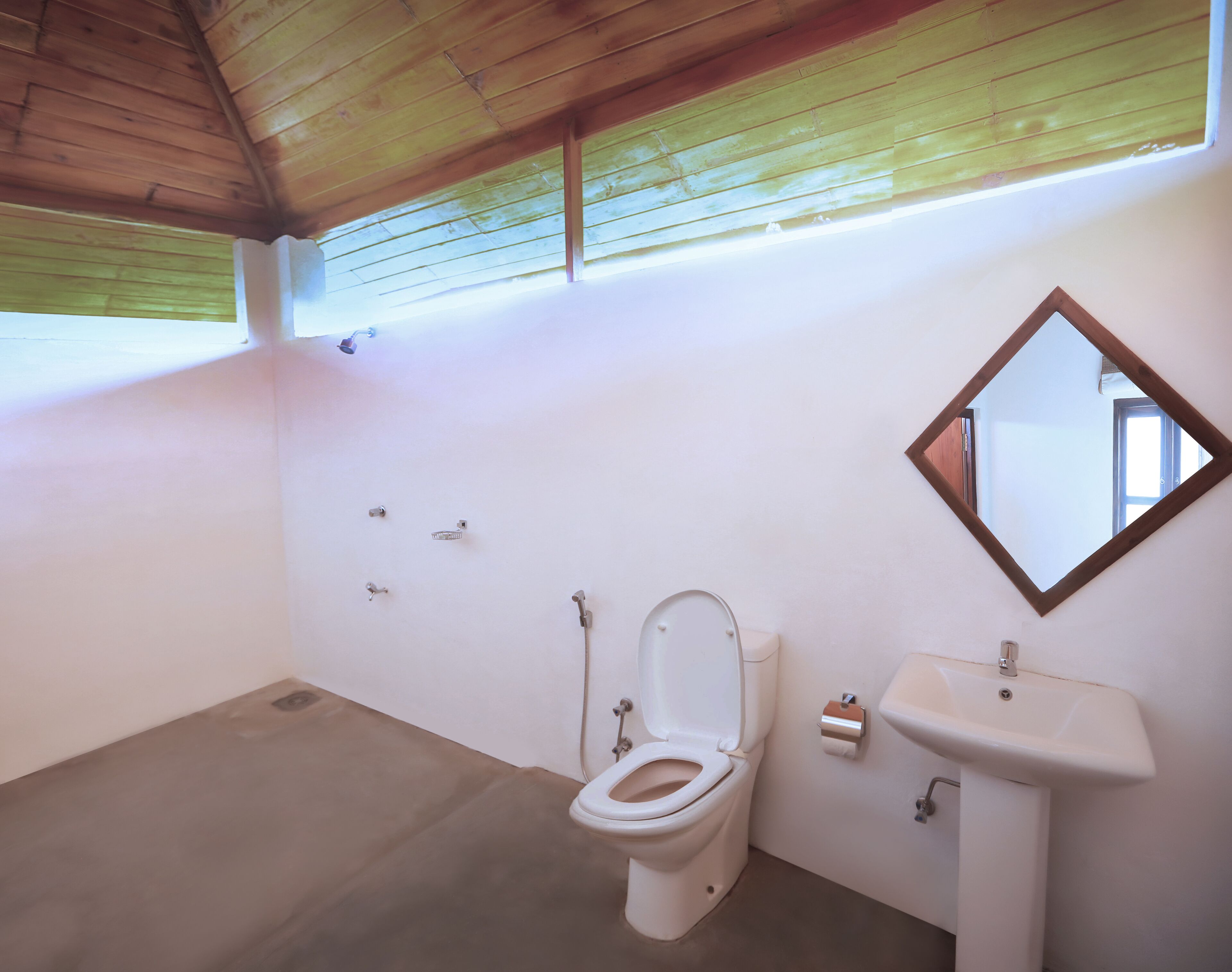Un baño con inodoro, lavamanos y espejo.