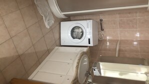 A compact laundry area with a washing machine, a drying rack, and a small sink. - Grand t 2 on Bastia (Bastia)