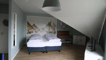 Un dormitorio con cama, escritorio, silla y estante en la pared.