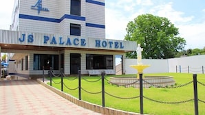 The exterior of the JS Palace Hotel with a clear entrance, a fountain, and a well-maintained lawn. - Js Palace Hotel (Alfenas)