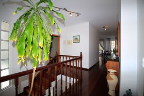 Eine Treppe mit Holzgeländern, einem Blumentopf und einer Vase auf der Empfangsdiele.