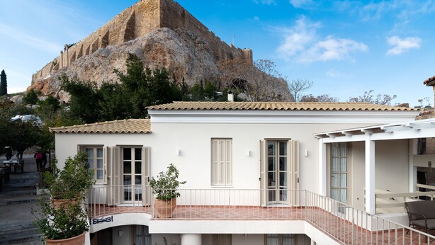 A building with a balcony overlooking a rocky hill. - Acropolis Suites (Athens)