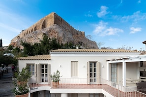 A building with a balcony overlooking a rocky hill.