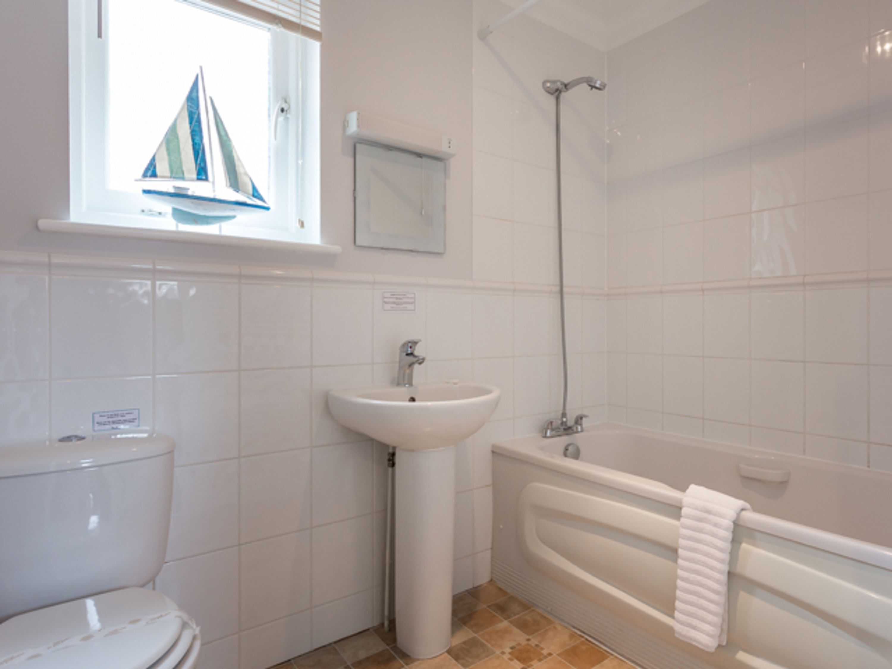 A bathroom with a toilet, sink, and bathtub.
