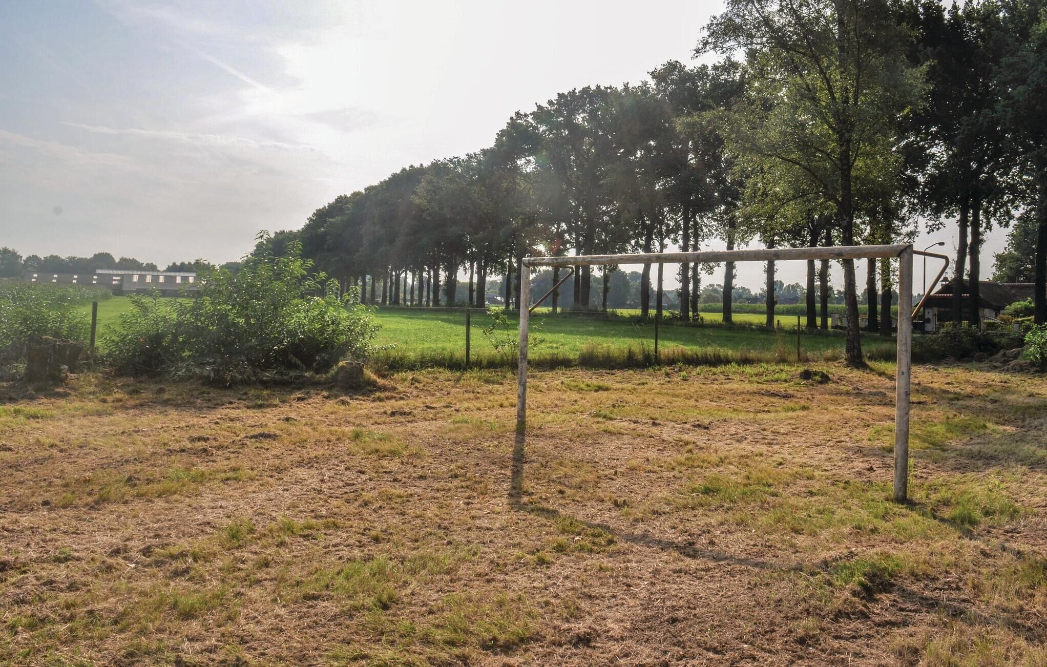 Ländliche Landschaft mit einer Metallkonstruktion im Vordergrund, möglicherweise ein Tor oder ein Zaun.