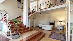 A spacious lobby with a grand staircase, a fireplace, and a seating area. - Scaligerorooms (Verona)