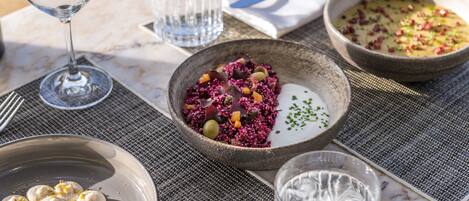 A table set with various dishes, including a bowl of purple vegetables, a bowl of soup, and dumplings.