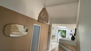 Een modern interieur met een trap, een hanglamp en een spiegel.