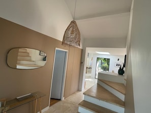 A modern interior with a staircase, a hanging light fixture, and a mirror. - House with pool near beach and Montpellier (Castelnau-Le-Lez)
