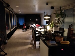 A modern kitchen with a dining area, a large window, and a ceiling fan. - Residenssi Lehtinen (Rovaniemi)