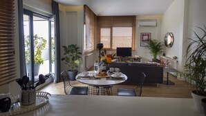 A modern living space with a dining area, a sofa, a TV, and potted plants. - GALATA M84  (Istanbul)