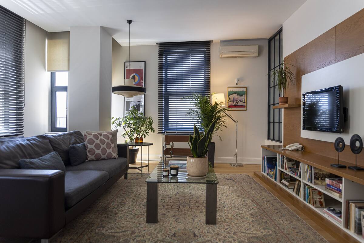 A modern living room with a sofa, coffee table, and bookshelf.
