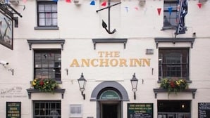 The exterior of The Anchor Inn, featuring a traditional facade with a prominent sign, windows, and flower boxes. - The Anchor Inn (Cowes)
