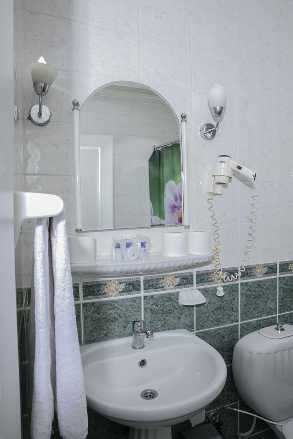 A bathroom with a sink, mirror, towel rack, and a hairdryer.