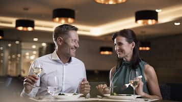A couple dining in a modern restaurant with pendant lighting and a contemporary interior design.