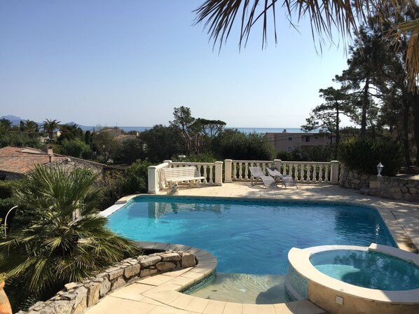 Een seizoensgebonden buitenzwembad en ligstoelen