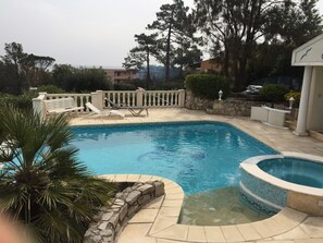 Een seizoensgebonden buitenzwembad en ligstoelen