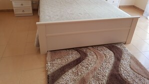 Ein Schlafzimmer mit einem Bett, zwei Nachttischen und einem gemusterten Teppich.