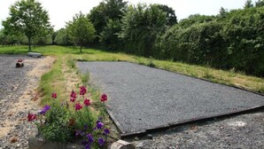 A gravel path leading to a paved area with a flower bed. - Charming farm with garden and BBQ in Bérigny (Bérigny)