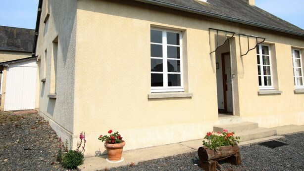 A single-story house with a beige exterior, a dark roof, and a small porch area with potted plants. - Charming farm with garden and BBQ in Bérigny (Bérigny)