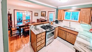 A modern kitchen with wooden cabinets, a marble countertop, and a built-in oven.
