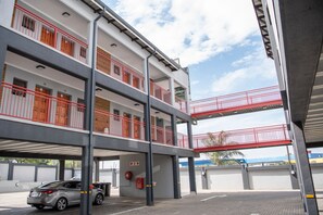 A multi-story parking garage with a car parked under a covered area. - Ecomotel Marlboro (Sandton)