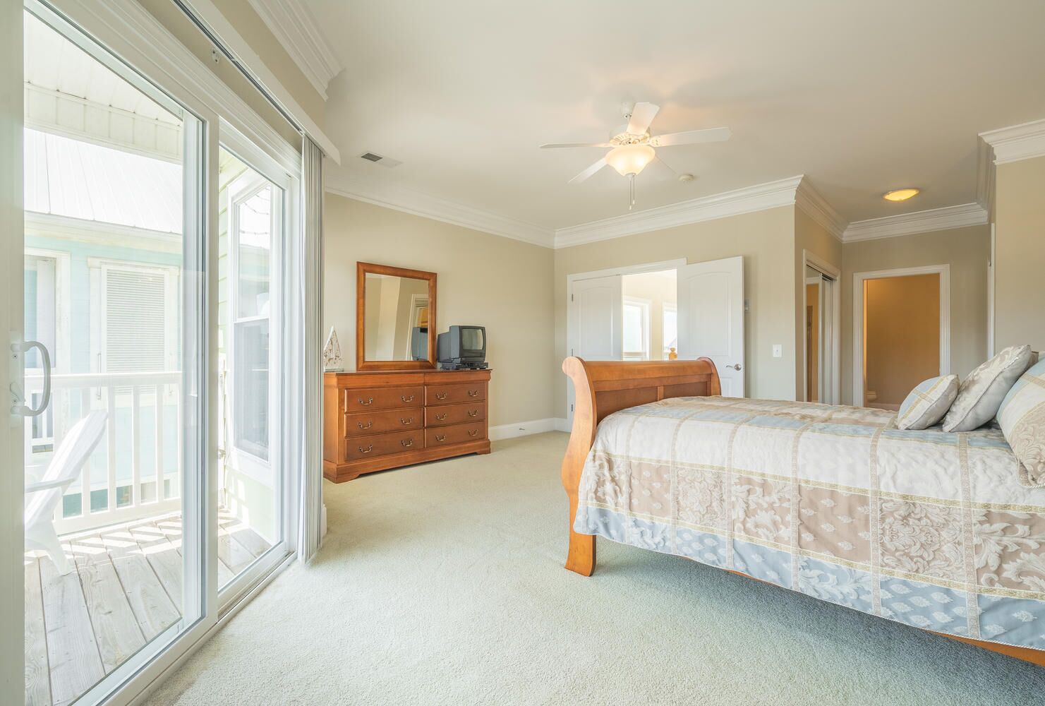 Une chambre à coucher avec un lit, une commode et un ventilateur de plafond.