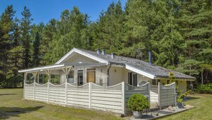 A small, single-story cabin with a porch, surrounded by dense forest. - 3 bedroom beautiful home in Ans By (Ans By)