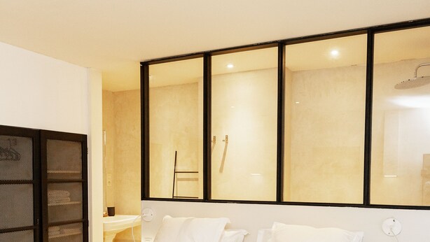 Una habitación de hotel con una cama grande, un escritorio y un espejo.