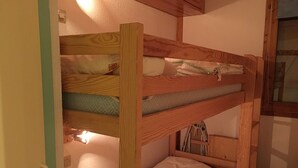 Ein Stockbett mit Holzgestell und einer Matratze.