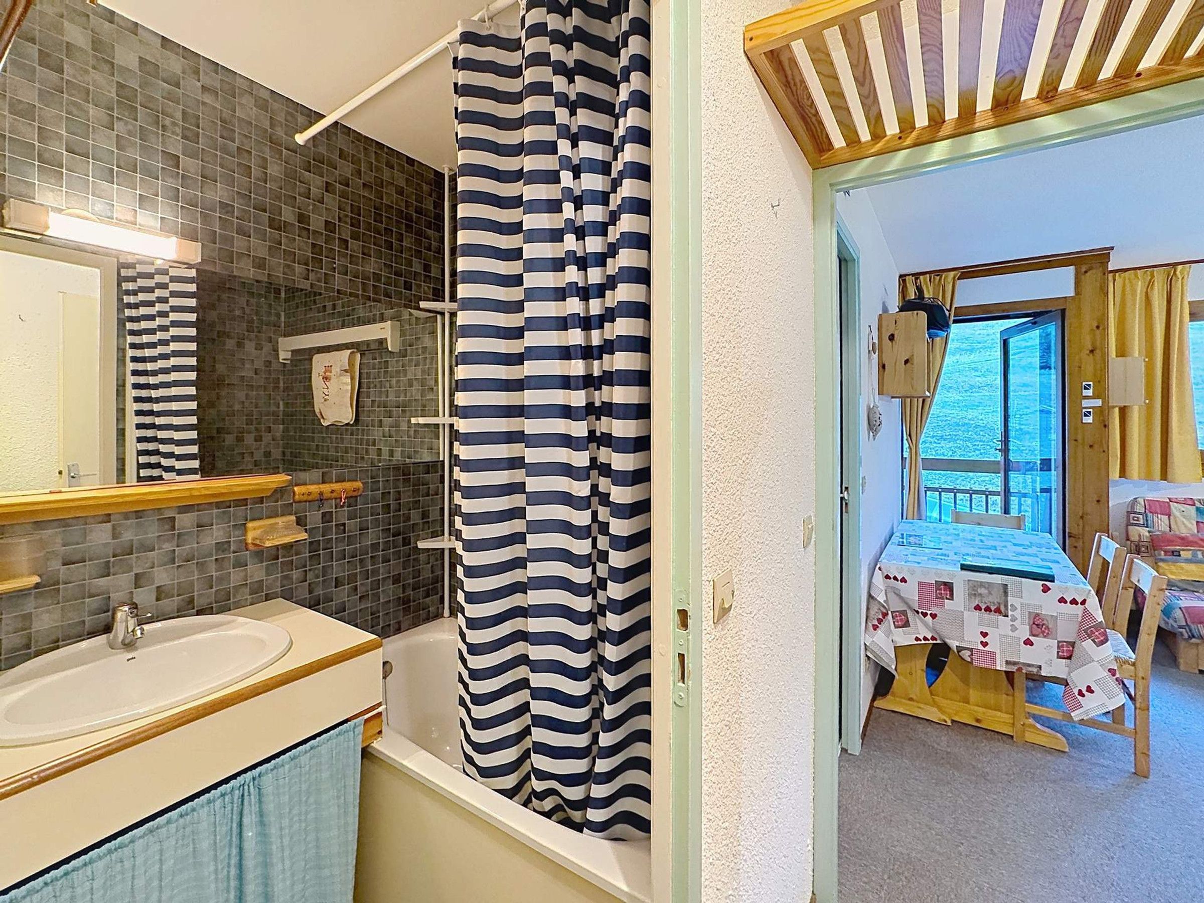 Une salle de bain avec une baignoire, un lavabo et un rideau de douche.
