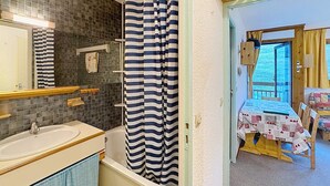 Une salle de bain avec une baignoire, un lavabo et un rideau de douche.