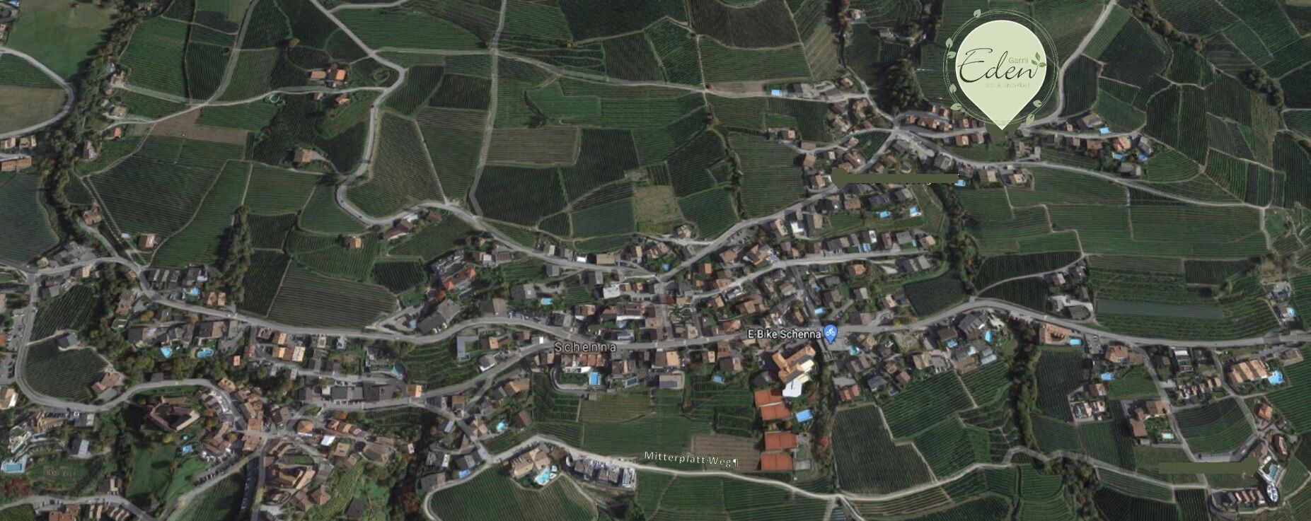 A rural village with narrow roads and houses surrounded by fields.