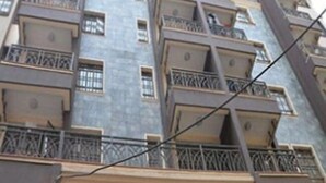 A multi-story residential building with balconies, satellite dishes, and a uniform architectural style.