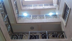 A multi-level building with balconies and a central open space.