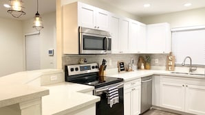A modern kitchen with white cabinetry, stainless steel appliances, and a granite countertop. - Family/ Kid Friendly Retreat Near the Beach, Atlantic Ave, Downtown Delray & FAU (Delray Beach)