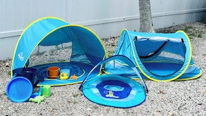 Two blue and yellow play tents with a small trampoline and various toys. - Family/ Kid Friendly Retreat Near the Beach, Atlantic Ave, Downtown Delray & FAU (Delray Beach)
