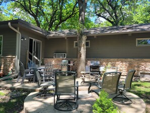 An outdoor patio with a stone fireplace, a grill, and outdoor furniture. - Your Family Vacation Starts Here, Less than a Mile from Arnold's Park! (Arnolds Park)