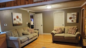 A cozy living room with two sofas, a coffee table, and a fireplace.