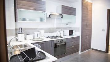 Appartement Deluxe, vue ville | Cuisine privée | Réfrigérateur, micro-ondes, four, plaque de cuisson