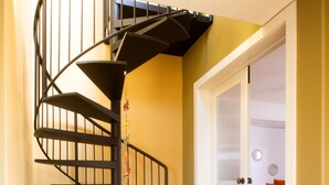 Un escalier en colimaçon avec un meuble en bois à sa base.