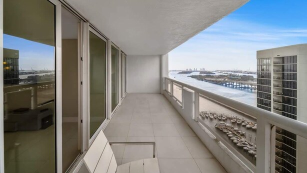Un balcón con vista a un paisaje urbano y una masa de agua.