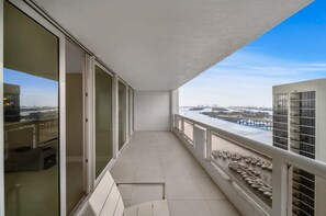 A balcony with a view of a cityscape and a body of water.