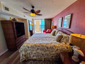A hotel room with a bed, a television, a ceiling fan, and a view of the ocean. - South Shore Villas 1203 (North Myrtle Beach)