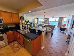 Enjoy ocean views from the kitchen and dining area, featuring a large island and round table.