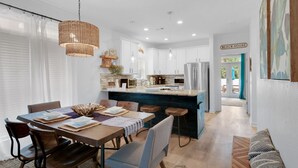 A modern kitchen with white cabinets, a central island, and stainless steel appliances. - Stay directly on 30A! Beautiful Beach House with private courtyard and panoramic views! Short walks to beach, pool, Rosemary and Alys! (Panama City Beach)