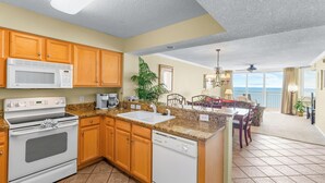 A kitchen with wooden cabinets, a microwave, an oven, and a dishwasher.