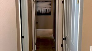 A narrow hallway with white doors on either side, leading to a room with a tiled floor and a ceiling light fixture. - Great NON-SMOKING, NO PETS ALLOWED..Easy to Get to, Short Drive To San Diego Fun (Bonita)