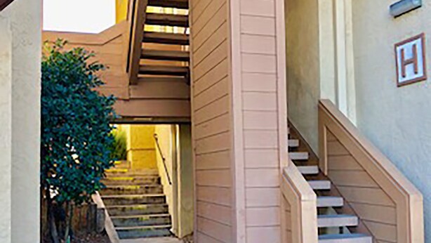 A narrow hallway with a wooden staircase leading to an upper level. - Great NON-SMOKING, NO PETS ALLOWED..Easy to Get to, Short Drive To San Diego Fun (Bonita)